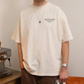 Person wearing a beige t-shirt with 'BIG DOG COFFEE' text, standing next to a coffee machine.